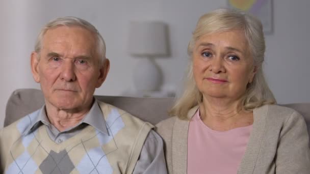 Старый муж и жена смотрят в камеру крупным планом, социальные реформы, пенсионные проблемы — стоковое видео