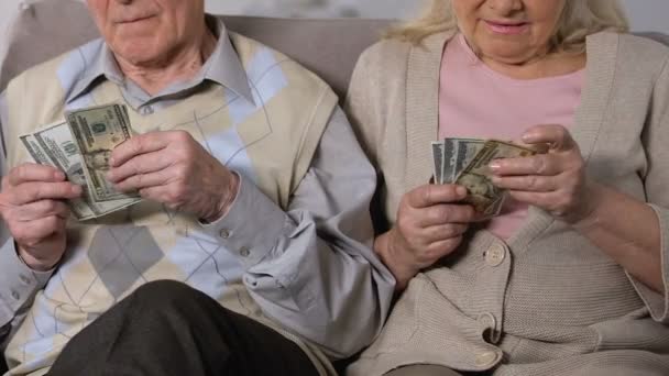 Retirado hombre y mujer contando dólares de cerca, falta de dinero, problema social — Vídeos de Stock