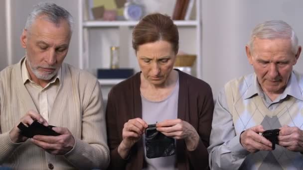 Smutna grupa osób w wieku pokazująca puste portfki, brak płatności socjalnych, emerytury — Wideo stockowe