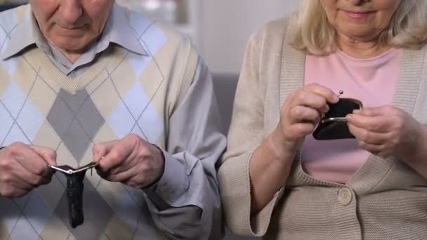 Несчастная пожилая пара показывает пустые бумажники и смотрит на камеру социальной незащищенности — стоковое видео