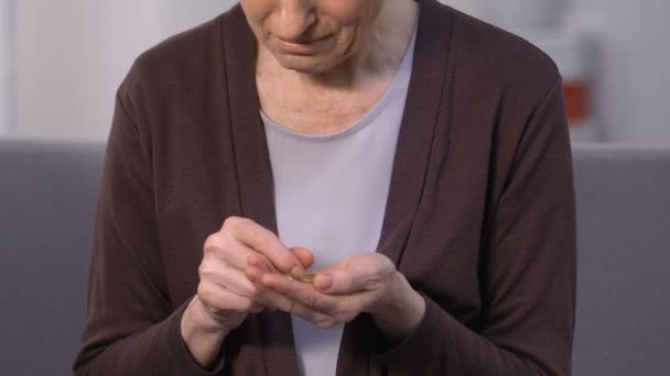Спритна стара жінка тримає монети, багатий старший чоловік рахує долари, соціальний розрив — стокове відео