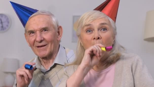 Funny aged couple in party hats enjoying celebration, having fun together — Stock Video