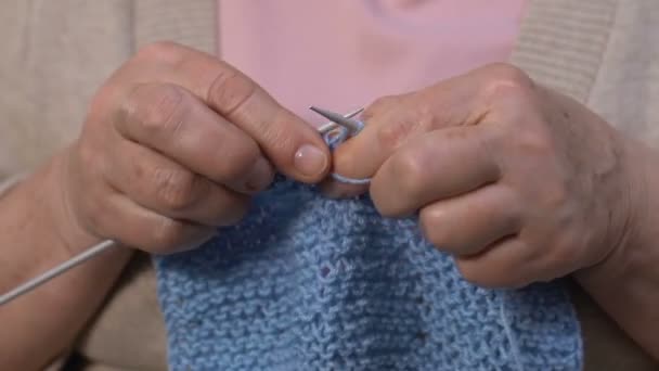Senior vrouw breien blauwe sjaal aan man, pensioen hobby, handen close-up — Stockvideo