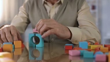 Yaşlı erkek yapma ev renkli ahşap küpler, konsantrasyon egzersiz, terapi
