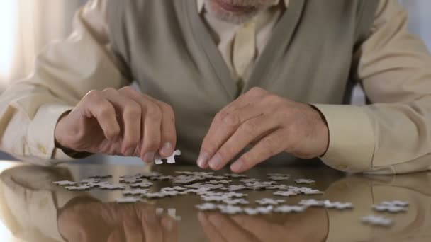 Opa probeert te zetten puzzel samen, concentratie oefening, motorische vaardigheden — Stockvideo