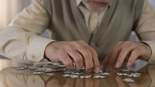 Pensionista masculino ensamblando rompecabezas en casa, rehabilitación de Alzheimer, hobby — Vídeo de stock