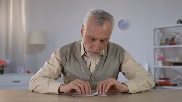 Homem velho combinando com sucesso quebra-cabeça, exercício para melhorar a função cognitiva — Vídeo de Stock