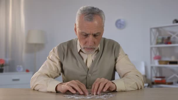 Alter Mann erfolglos versucht, Puzzle zu kombinieren, Frühstadium der Demenz — Stockvideo