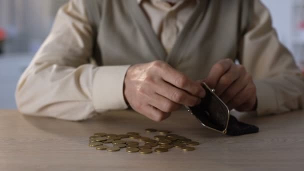 Пенсионер кладет немного монет в бумажник, понятие бедности, низкое социальное обеспечение — стоковое видео