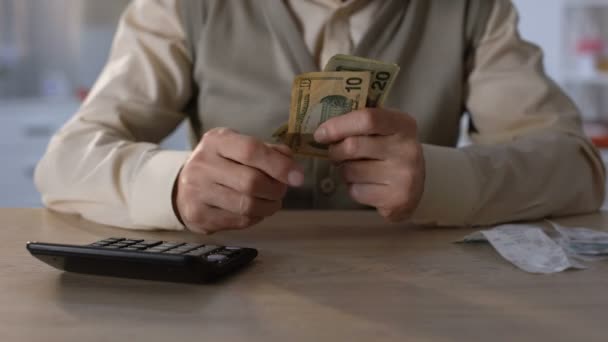 Пенсионер считает доллары, планирует семейный бюджет, выплачивает кредиты и долги — стоковое видео