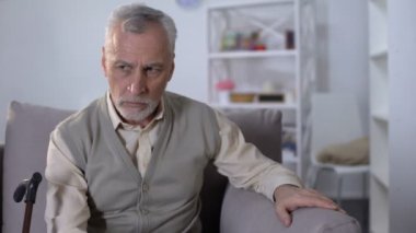 Üzgün yaşlı adam kanepede oturan, sağlık sorunları üzerinde düşünme, düşük emeklilik