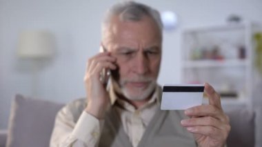Rahatsız yaşlı adam cep telefonu tarafından kredi kartı hakkında banka destek hizmeti ile konuşan
