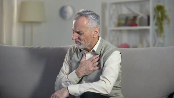 Пенсионер страдает от боли в груди, сердечного приступа, проблем с дыханием, астмы — стоковое видео