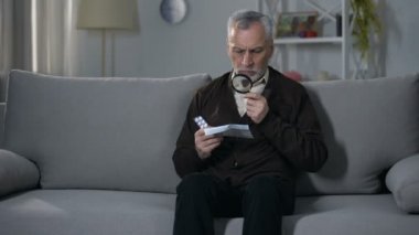 Yaşlı adam büyüteç ile hapları için öğretim okuma, görme bozukluğu tedavisi