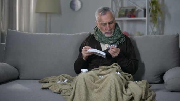 Uomo malato leggere le istruzioni per l'assunzione di compresse di sollievo dall'influenza, consulenza medica — Video Stock