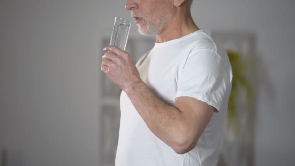 Senior man drinken gezuiverd water uit glas, herstel van de pH-balans, gezondheidszorg — Stockvideo