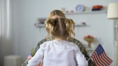 Joyful Amerikan asker kadın ulusal bayrak, vatansever ile küçük kız kardeşi sarılma