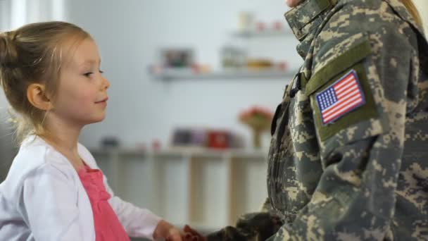 Petite fille mignonne embrassant soldat mère en uniforme, forces armées devoir séparation — Video