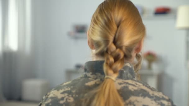 Hijita abrazando a la madre soldado en uniforme de camuflaje, regreso a casa de guerra — Vídeos de Stock