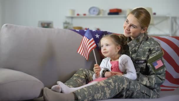 Veterana americana e hija pequeña con bandera observando marcha militar — Vídeo de stock