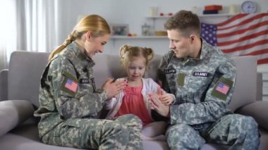 Neşeli Abd askeri çift evde küçük kızı ile pat-a-cake oynarken