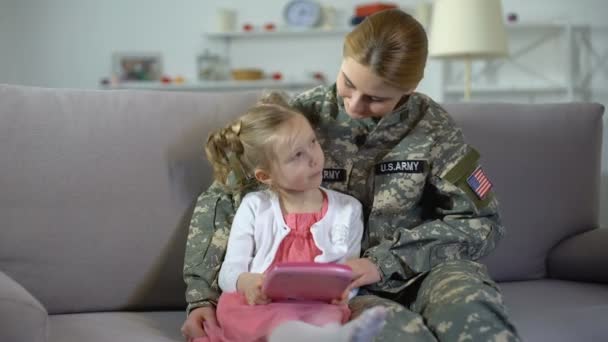 Ibu dengan seragam tentara AS dan putri kecil bermain game di tablet bersama-sama — Stok Video