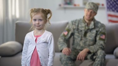 Neşeli amerikan asker baba kameraya bakarak sevimli kızı hayran, gurur