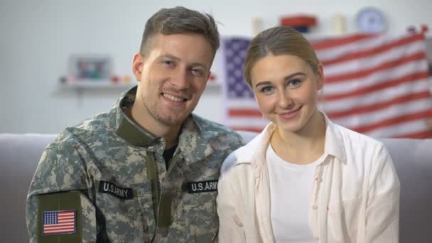 Sonriente pareja de soldado americano y su esposa sosteniendo panecillo firmar futuros padres — Vídeo de stock