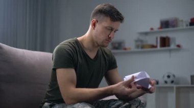 Erkek asker aileden mektup okuma ve gülümseyen, destek, silahlı kuvvetler görevi