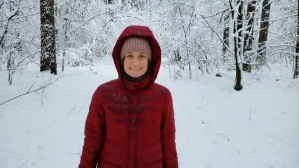 Uśmiechnięta kobieta spacery w śniegu pokryte lasem, ciesząc się zimą natura, relaks — Wideo stockowe