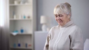Üzgün yaşlı bayan huzurevinde tek başına oturan ve ağlama, sağlık sorunları