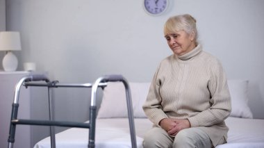 Çerçeve, sakatlık eklem cerrahisi sonra yürüyüş yakın oturan yaşlı kadın