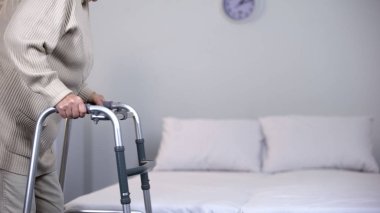 Çerçeveli yaşlı kadın, travma rehabilitasyonu, eklem cerrahisi, fizik tedavi