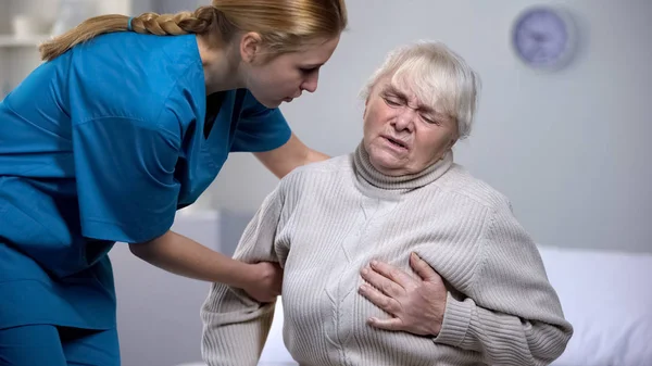 特別養護老人ホーム従業員老婦人の心痛みを感じて 医療に関する世話 — ストック写真