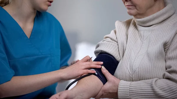 Terapis Mengukur Wanita Tua Yang Sedih Tekanan Darah Masalah Kesehatan — Stok Foto