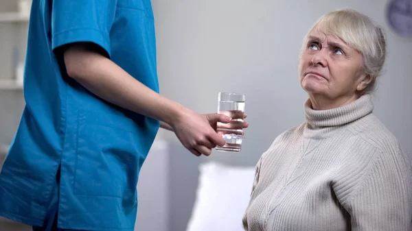 Ontevreden Oudere Vrouw Weigeren Van Pillen Van Medische Werknemer Verpleeghuis — Stockfoto