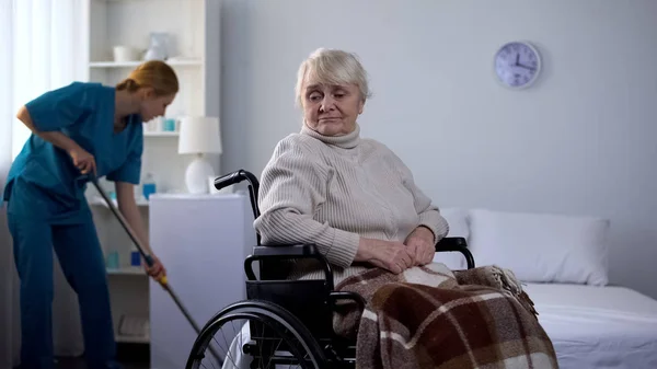 Donna Triste Sedia Rotelle Guardando Inserviente Ospedale Pulizia Camera Centro — Foto Stock