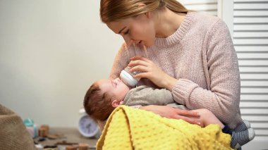 Young mother feeding infant from bottle, problems with breast feeding, mastitis clipart