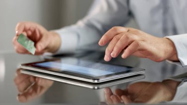 Tablet dokunmatik ekran, alışveriş uygulaması ile kart numarasını giren erkek işçi
