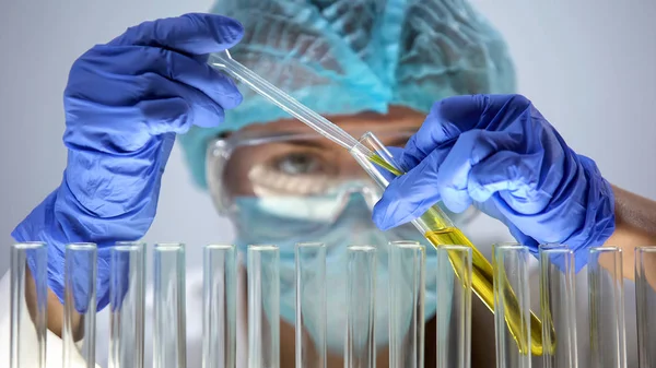 Επιστήμονας Μάσκα Γάντια Ρίχνει Κίτρινο Υγρό Δοκιμή Σωλήνα Εργαστηριακό Πείραμα — Φωτογραφία Αρχείου
