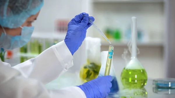 Wetenschapper Toevoegen Van Blauwe Vloeistof Buis Met Gele Olieachtige Substantie — Stockfoto
