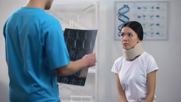 Mužský chirurg, který informuje pacientku v pěnové krční objímce špatný výsledek rentgenové — Stock video