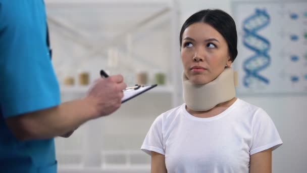 Médico masculino que da cuenta al paciente sorprendido en cuello de espuma, medicina costosa — Vídeo de stock