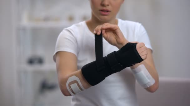 Young sportswoman applying titan wrist brace rehabilitation after trauma, health — Stock Video