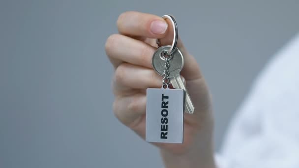 女性紧握钥匙串与度假村字，豪华酒店服务，度假 — 图库视频影像