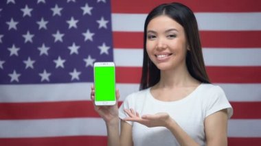 Yeşil ekran ile akıllı telefon gösteren kız, arka planda bize bayrak, çevirmen uygulaması