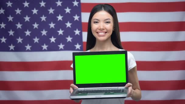 Mujer sosteniendo el ordenador portátil con pantalla verde, bandera de EE.UU. en el fondo, lecciones de idiomas — Vídeos de Stock