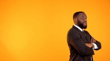 Baştan çıkarıcı afro-amerikan erkek formalwear çapraz elleri ile kameraya bakarak