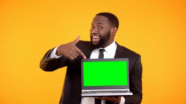 Neşeli siyah yöneticisi prekeyed dizüstü bilgisayar, reklam için yer gösteren