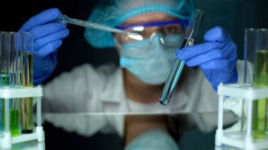 Test tüpündeki tortulara su örneği ile bakan laboratuvar çalışanı, ekoloji